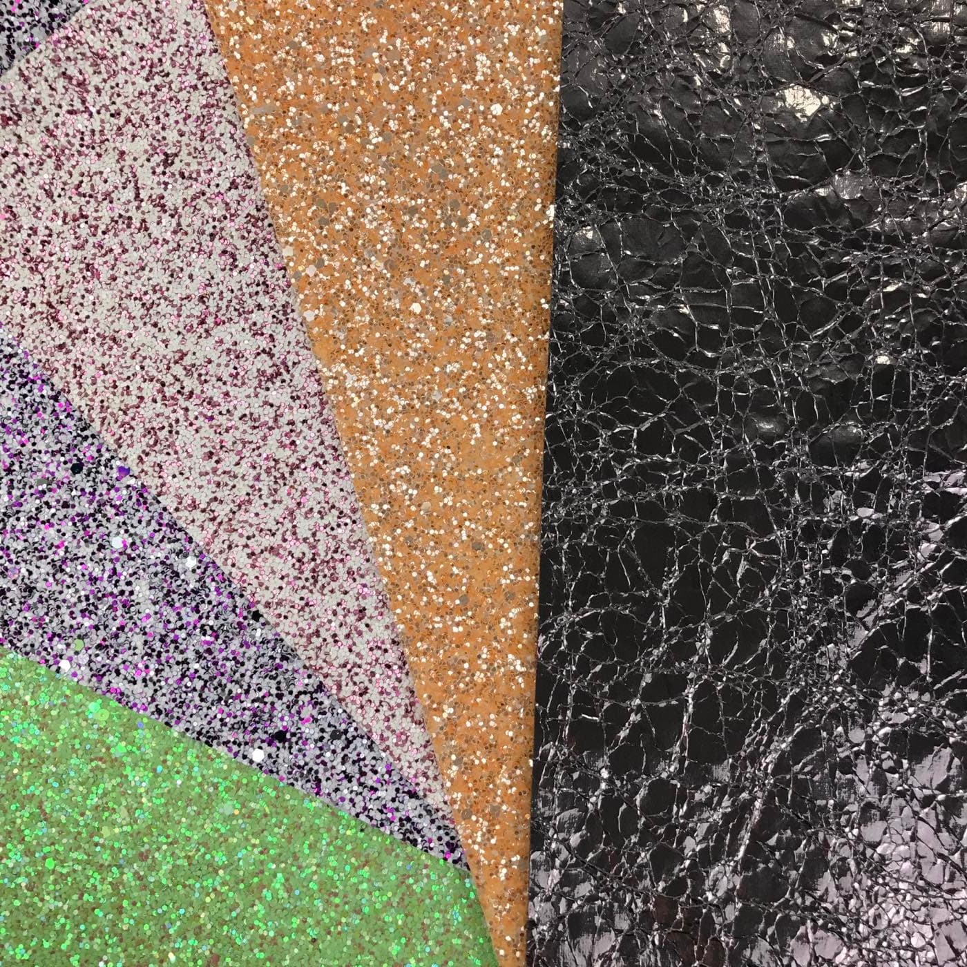 Glitter fabric and crackle leather swatches fanned out diagonally across each other on the table.